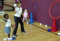 Girl throwing wiffle ball through hoop